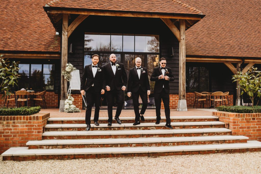 the grooms men walking towards a berkshire wedding photographer at the post barn newbury 