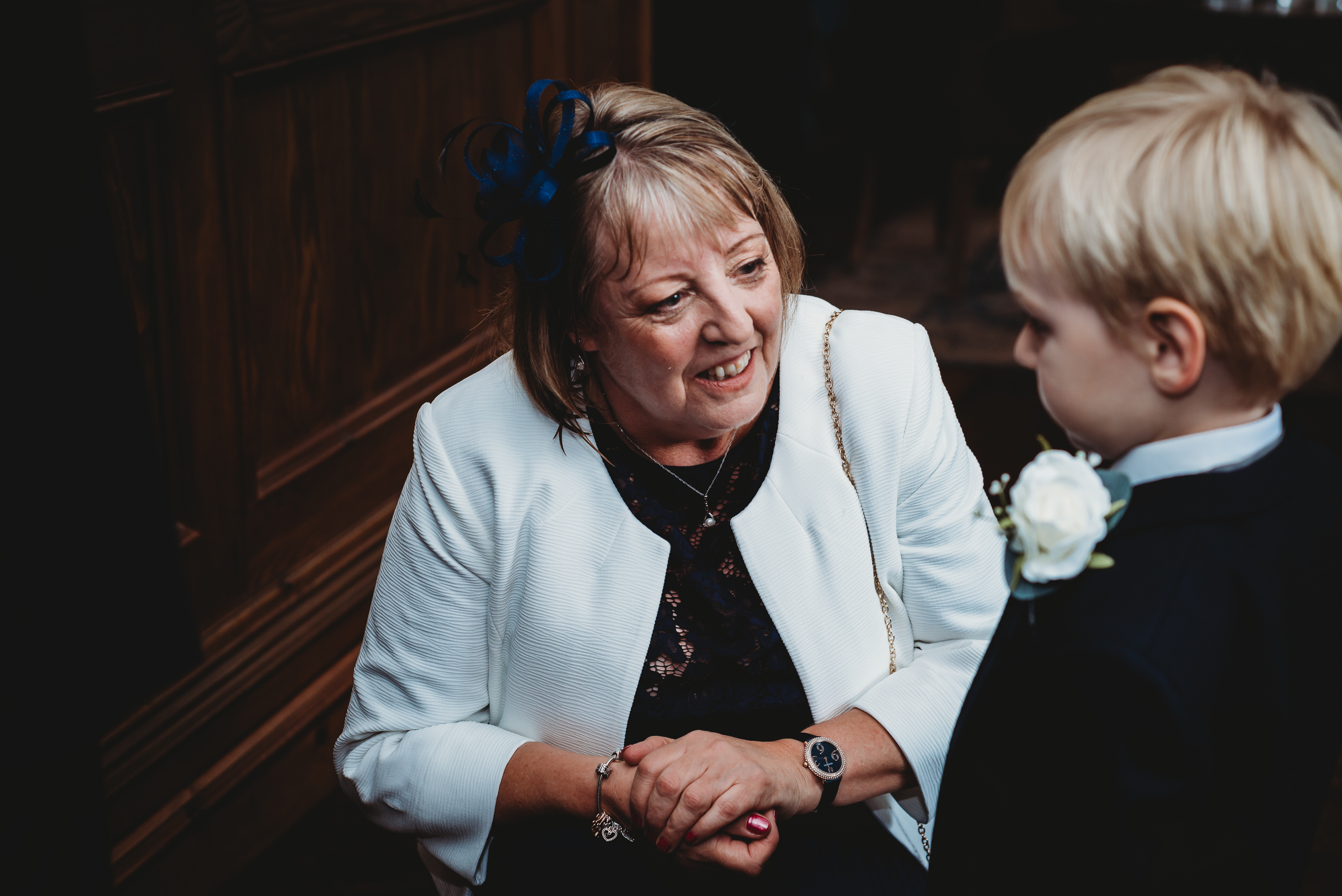 a grandma bending down to speak to her grandson before a wedding