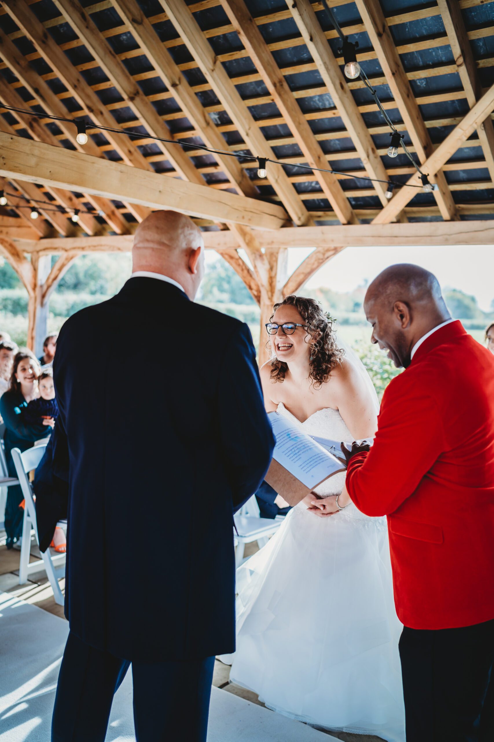 a bride and groom laughing as they are being married by a celebrant for a hampshire wedding
