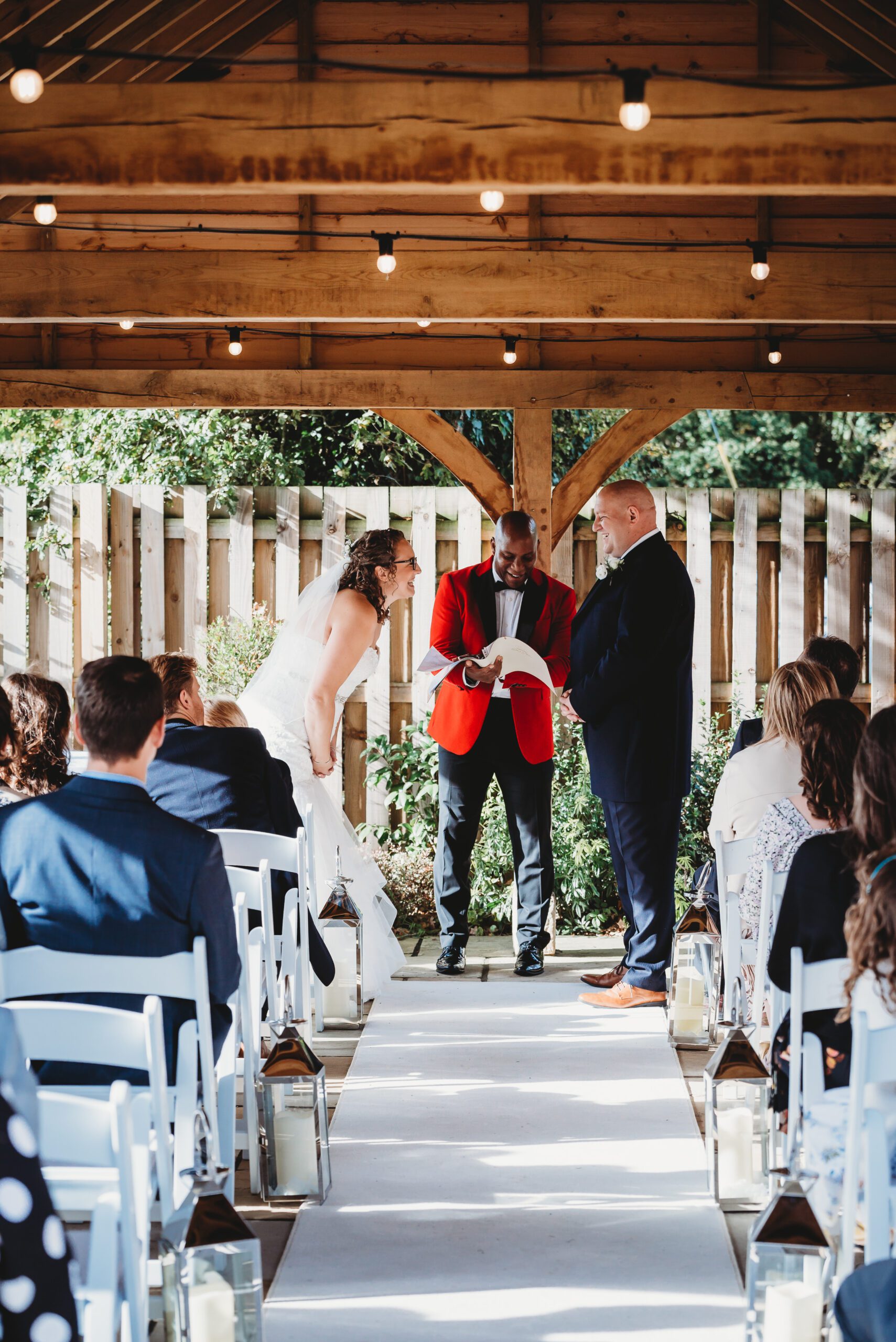 a bride and groom laughing as they get married by a celebrant taken by a hampshire wedding photographer 