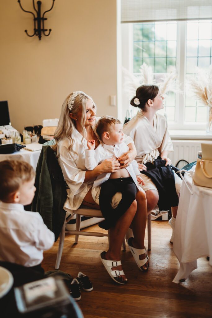 a bride getting her son ready before her wedding at a barn venue in newbury 