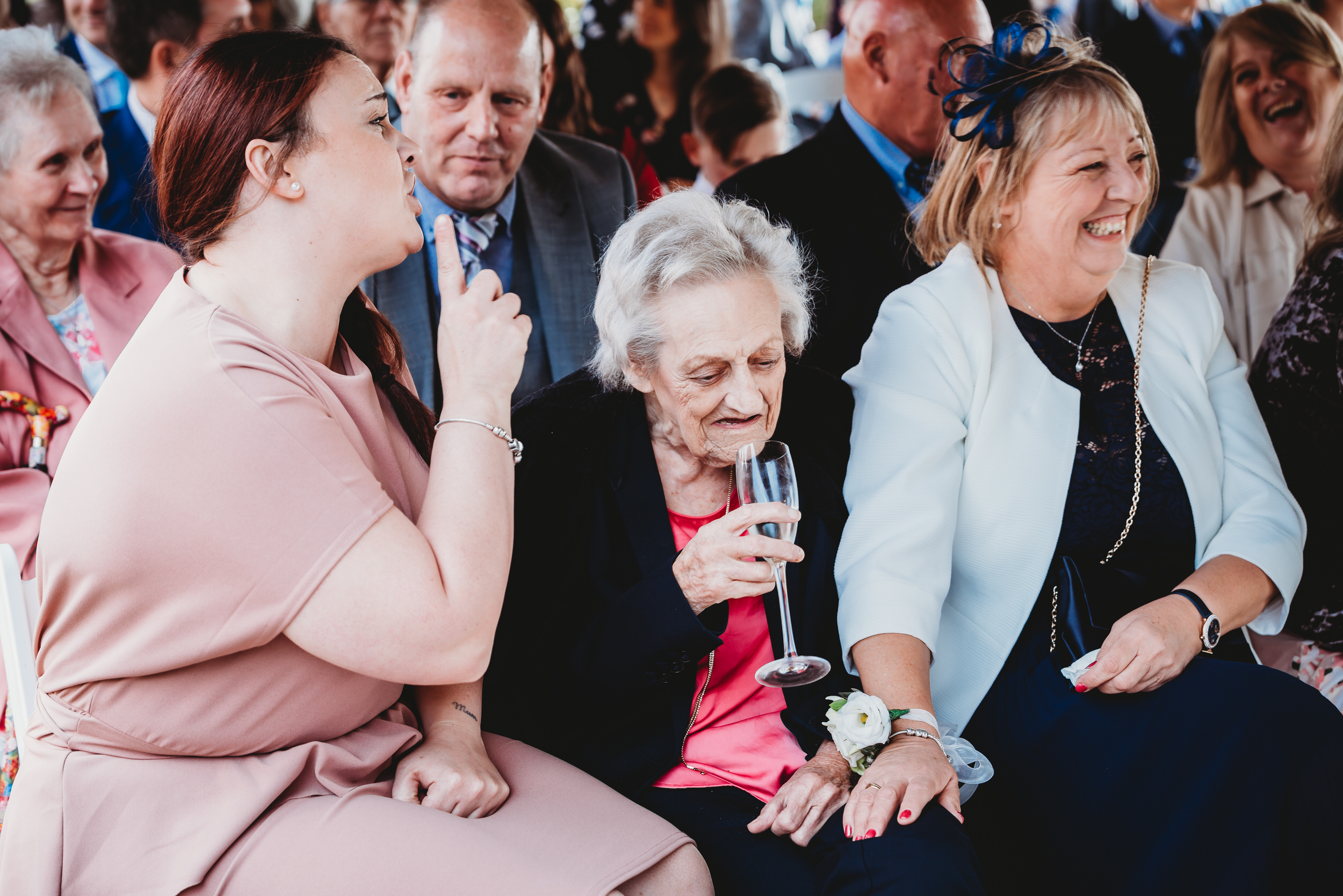 an elderly lady being told to be quiet during a wedding ceremony