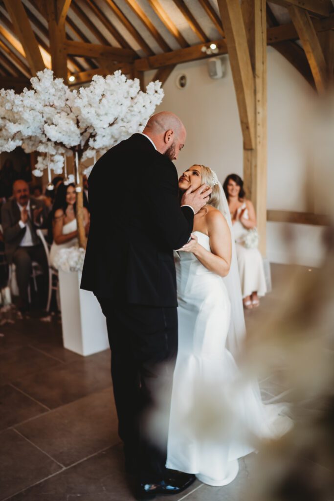 a newbury wedding photography image of a groom looking down at his bride just after the first kiss 