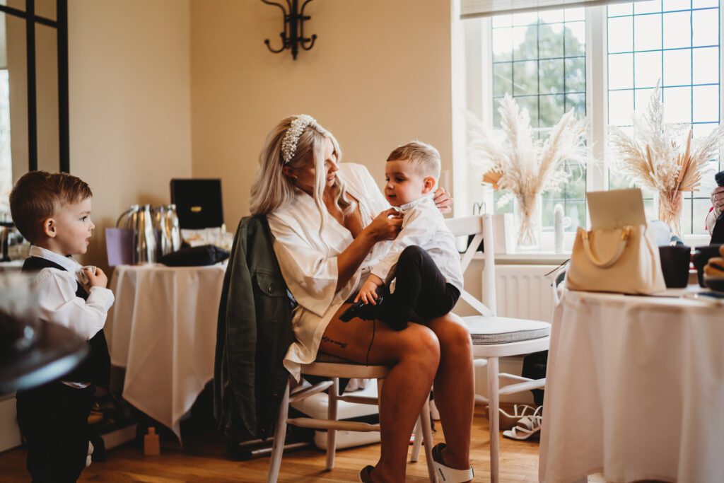 a bride getting her son ready before her wedding at a barn venue in newbury 