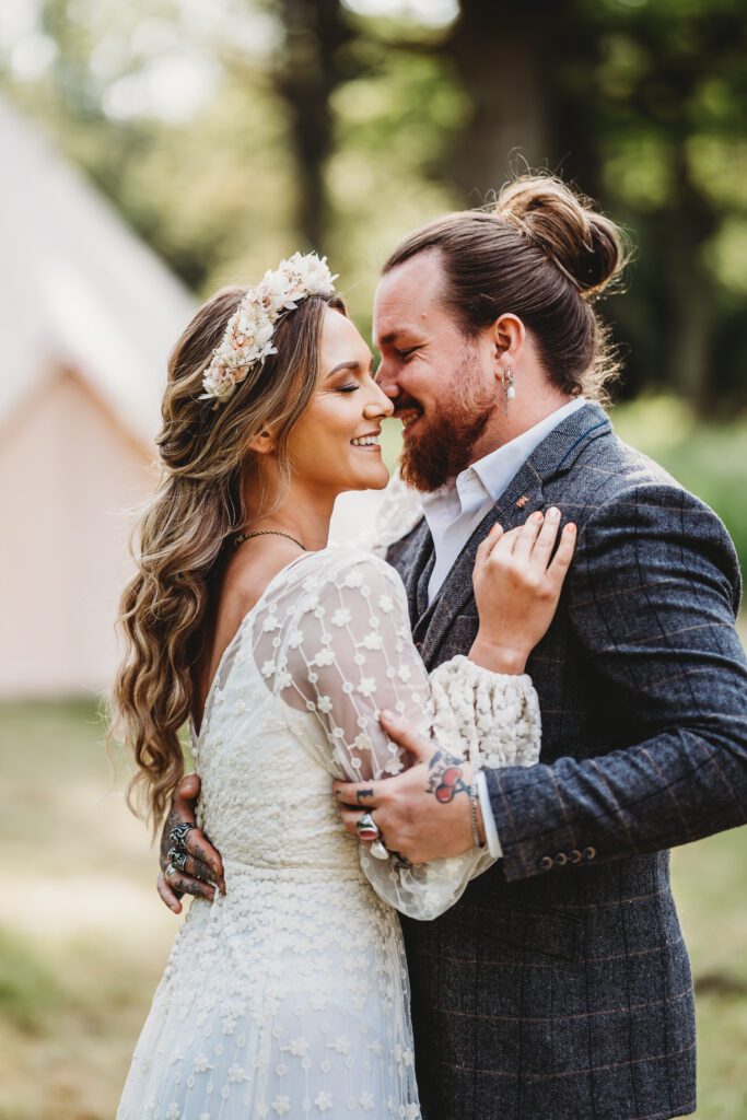 a bride and groom laughing and cuddling together taken by a Festival wedding Photographer