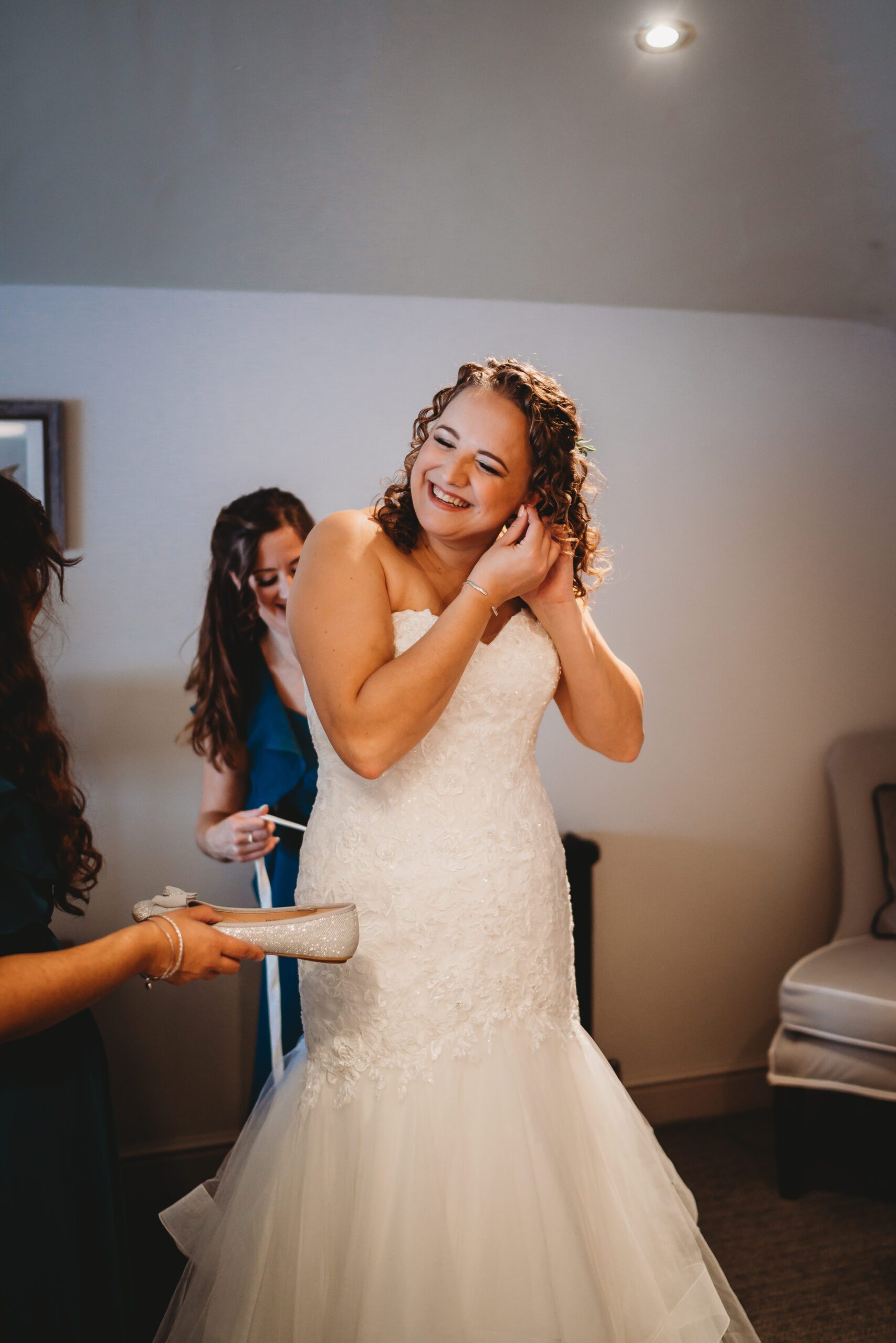 a bride putting her earrings in before her wedding