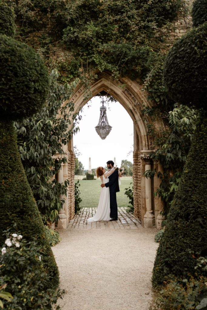 a bride and groom cuddling under an outdoor chandelier for a euridge manor wedding photographer 