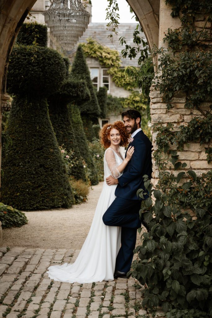 a bride leaning into her new husband as taken by a cotswold wedding photographer 