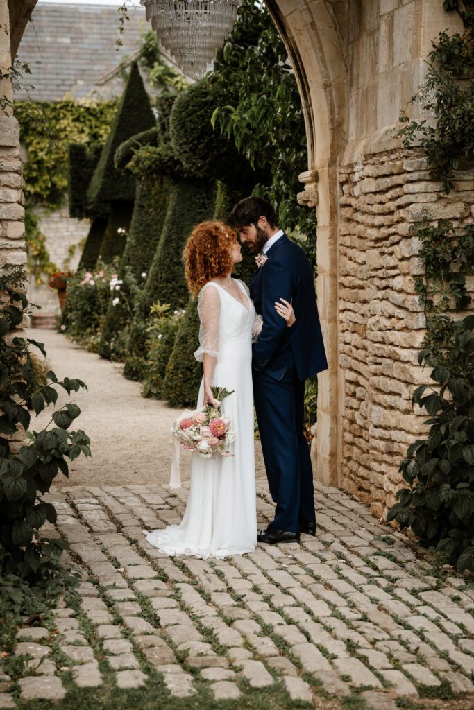 a bride leaning into her new husband after their Cotswolds wedding taken by a euridge manor wedding photographer 