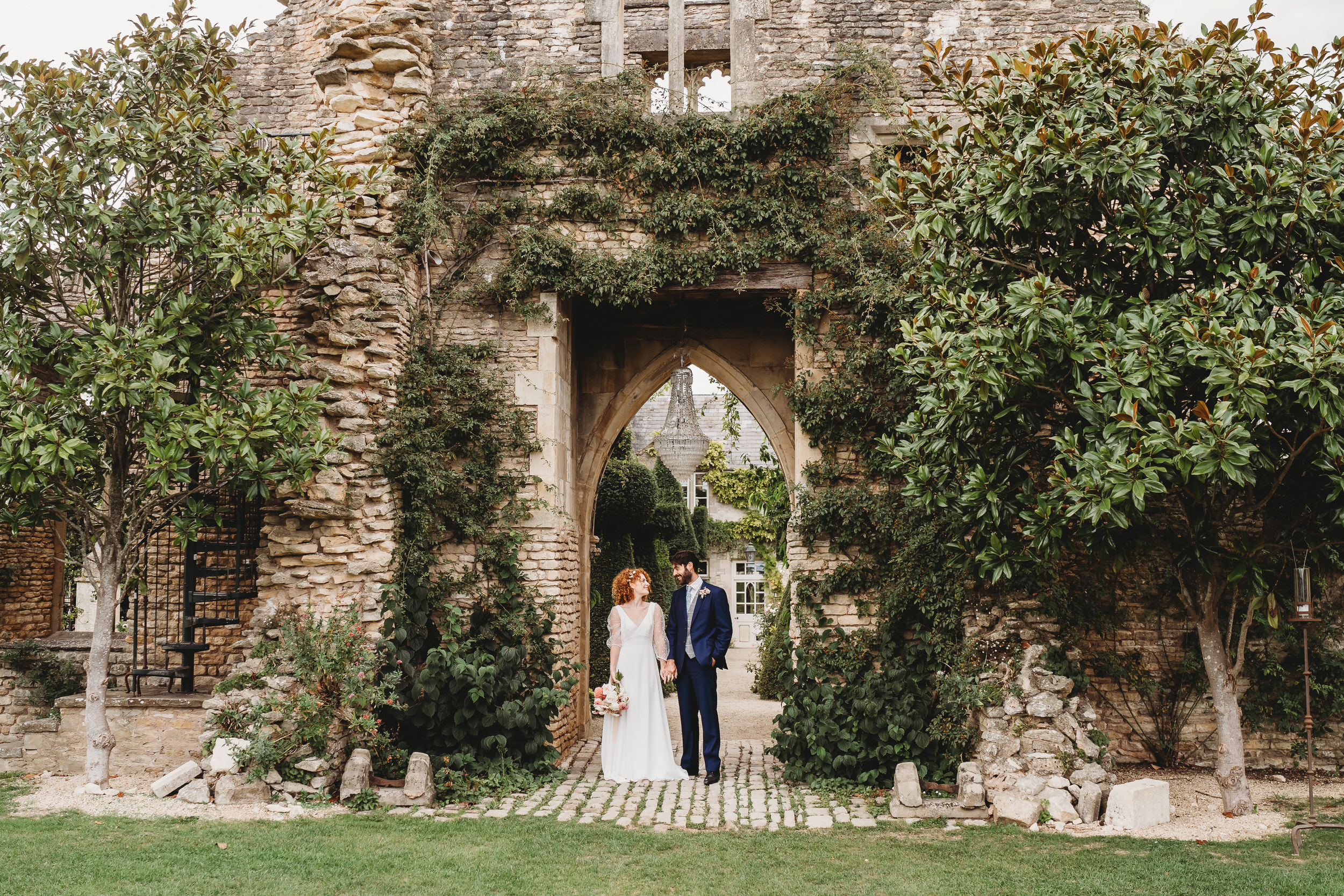 a bride and groom stood under the ruins at Euridge Manor after their wedding taken by a euridge manor wedding photographer