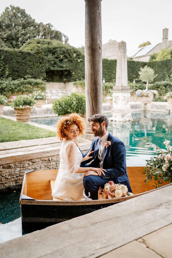 a bride and groom in a boat cuddling up after their wedding as taken by a euridge manor wedding photographer