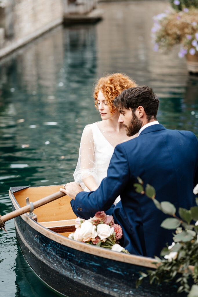 a groom rowing a boat on a lake with his new bride for a euridge manor wedding photographer