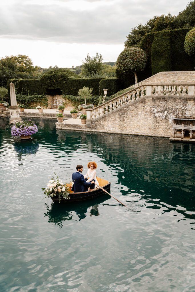 a groom rowing a boat on a lake with his new bride for a euridge manor wedding photographer