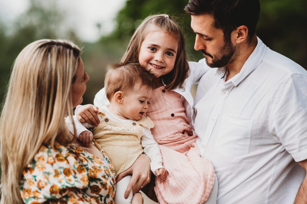 a close up of a family cuddling in close and laughing