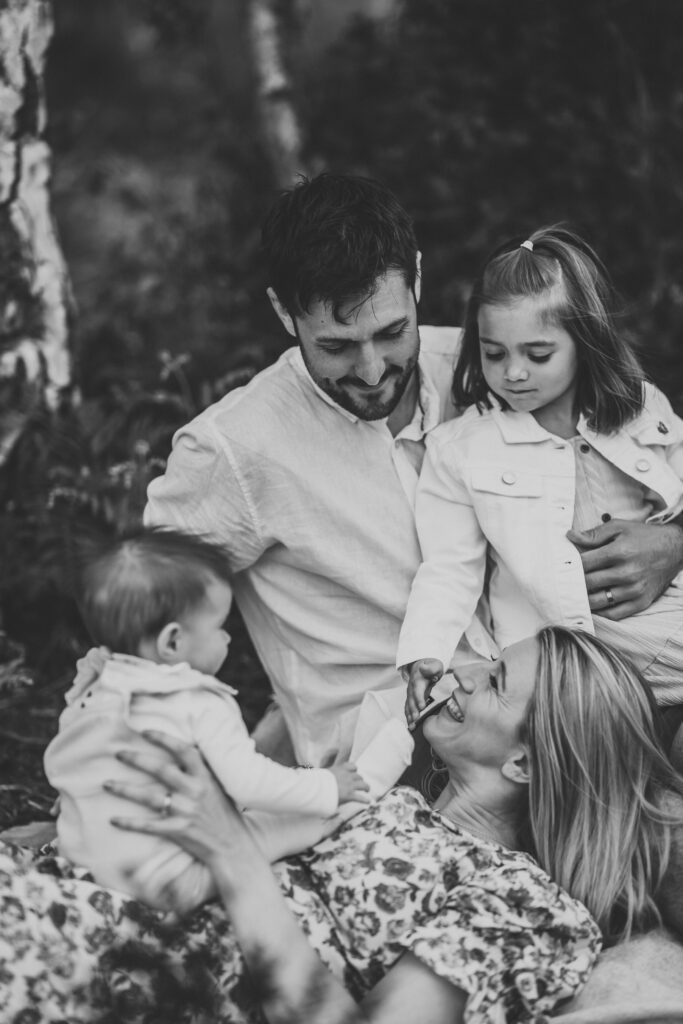 a family sat around each other smiling and chatting