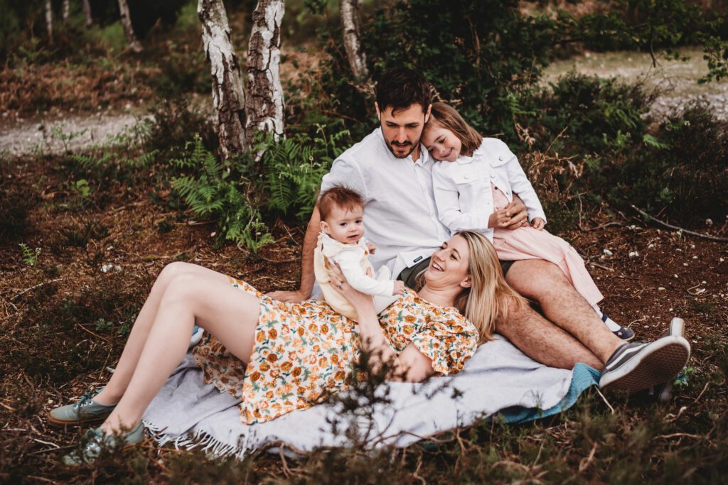 a family sat around each other smiling and chatting for a summer family photoshoot in Newbury