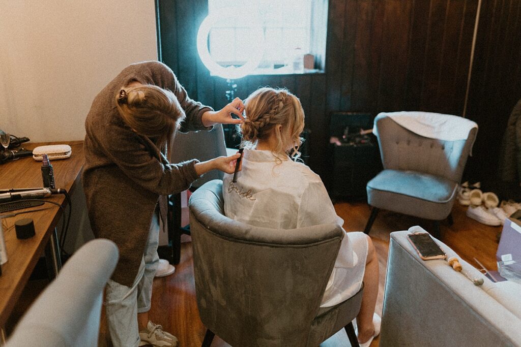 a bride having her hair done during bridal prep at Ufton Court