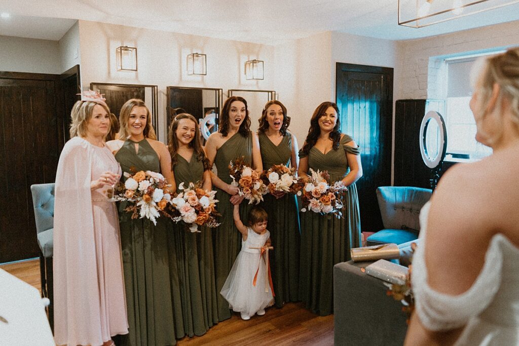 the bridesmaids reactions as they see the bride for the first time