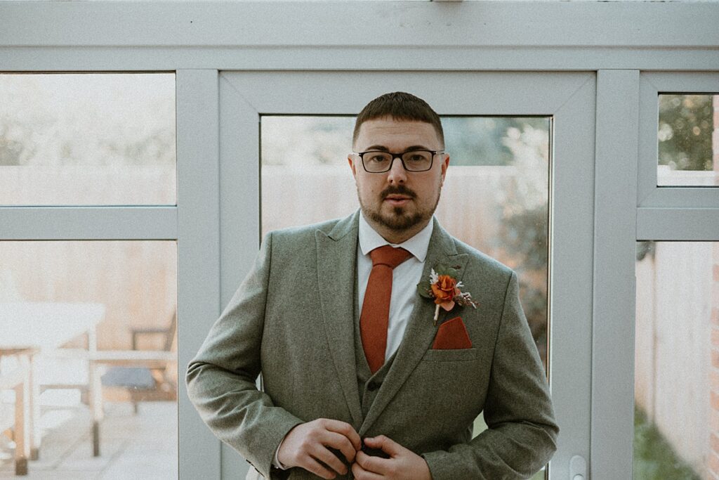 a groom in his suit and ready for his wedding day to start