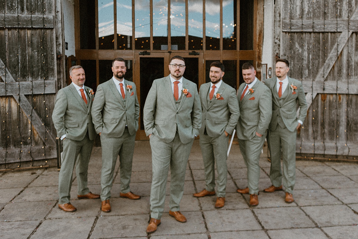 a line up of groomsmen posing for a luxury Ufton Court Wedding Photographer before his wedding