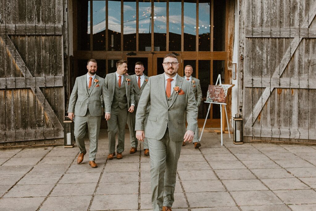 a line up of groomsmen posing for a luxury Ufton Court Wedding Photographer before his wedding