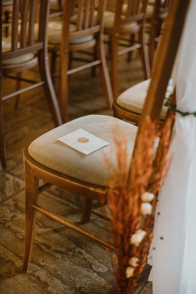 a close up of a decorated chair in a wedding ceremony barn at Ufton Court Aldermaston