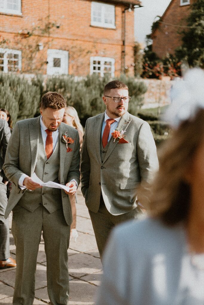 a groomsmen checking his list of duties with the groom before his wedding