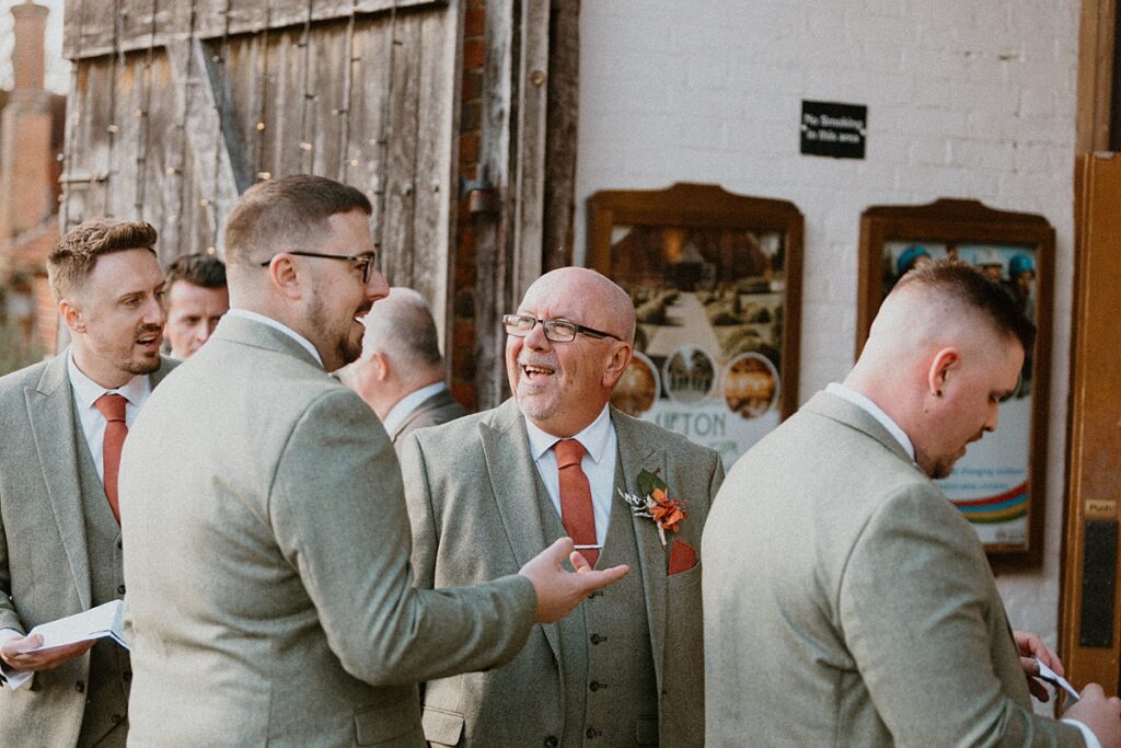 a groom joking with his dad before his wedding at Ufton Court