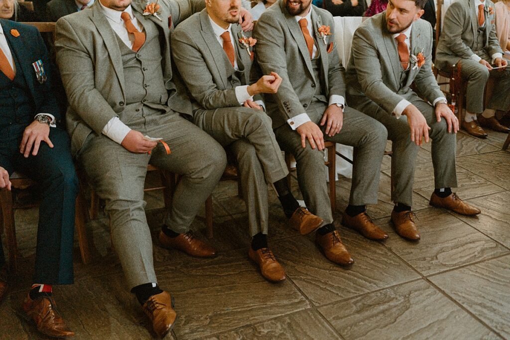 a close up of the groomsmen sat at the front of the ceremony room at Ufton Court