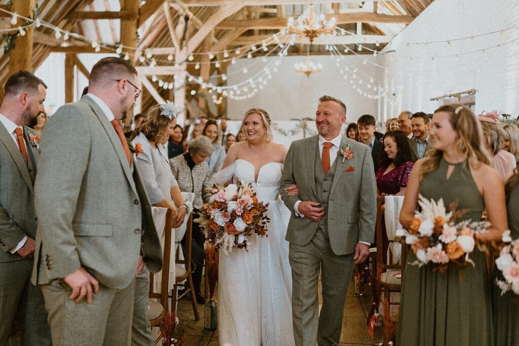 a bride being walked down the aisle at Ufton Court