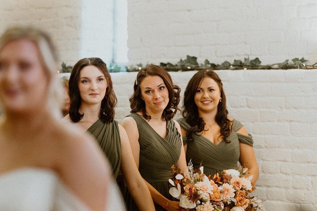 three bridesmaids looking at a bride affectionately