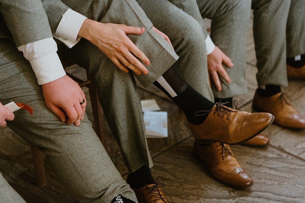 a close up of the groomsmens shoes and socks