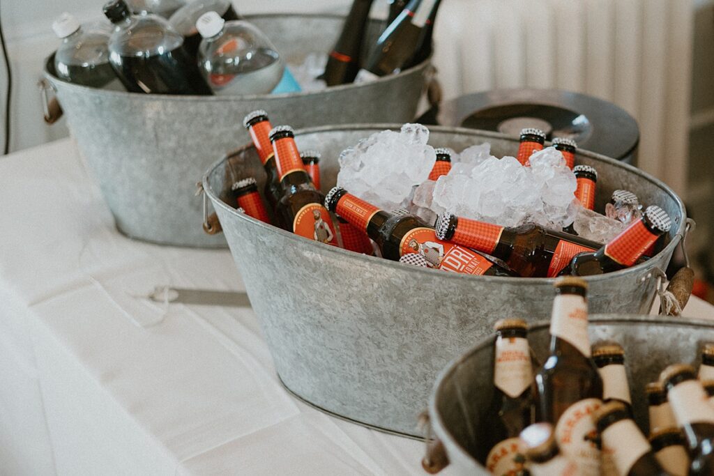 metal ice buckets filled with ice and beer ready for guests at a wedding reception at Ufton Court