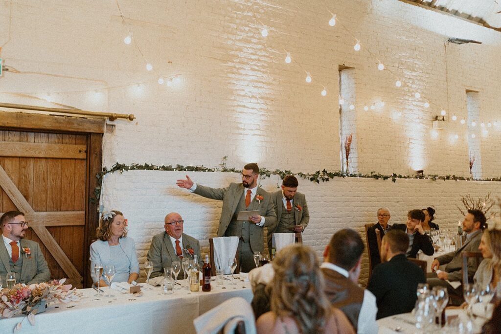 2 bestmen stood up giving a speech at a wedding at Ufton Court