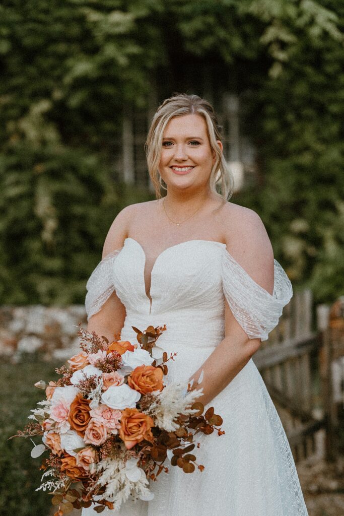 a beautiful bride looking at the camera holding her bouquet for a luxury wedding photographer during bridal photos