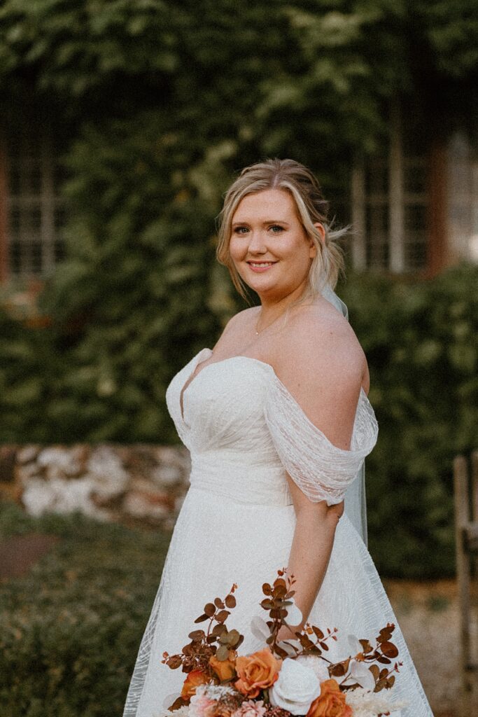 a bride looking at the camera during her bridal portraits at her wedding at Ufto Court