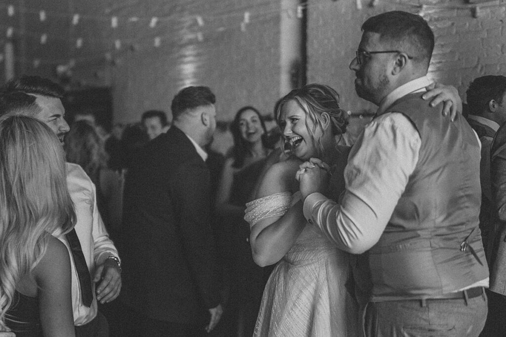 a bride and groom dancing and laughing with their guests at their wedding party at Ufton Court Berkshire