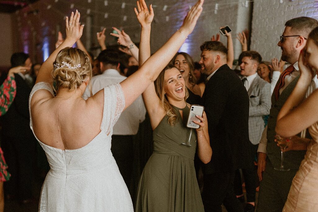 a bride singing and dancing with her sister at her wedding party