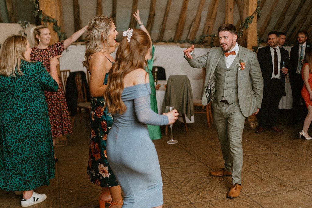 wedding guests dance and sing together during a wedding party at Ufton Court near Newbury