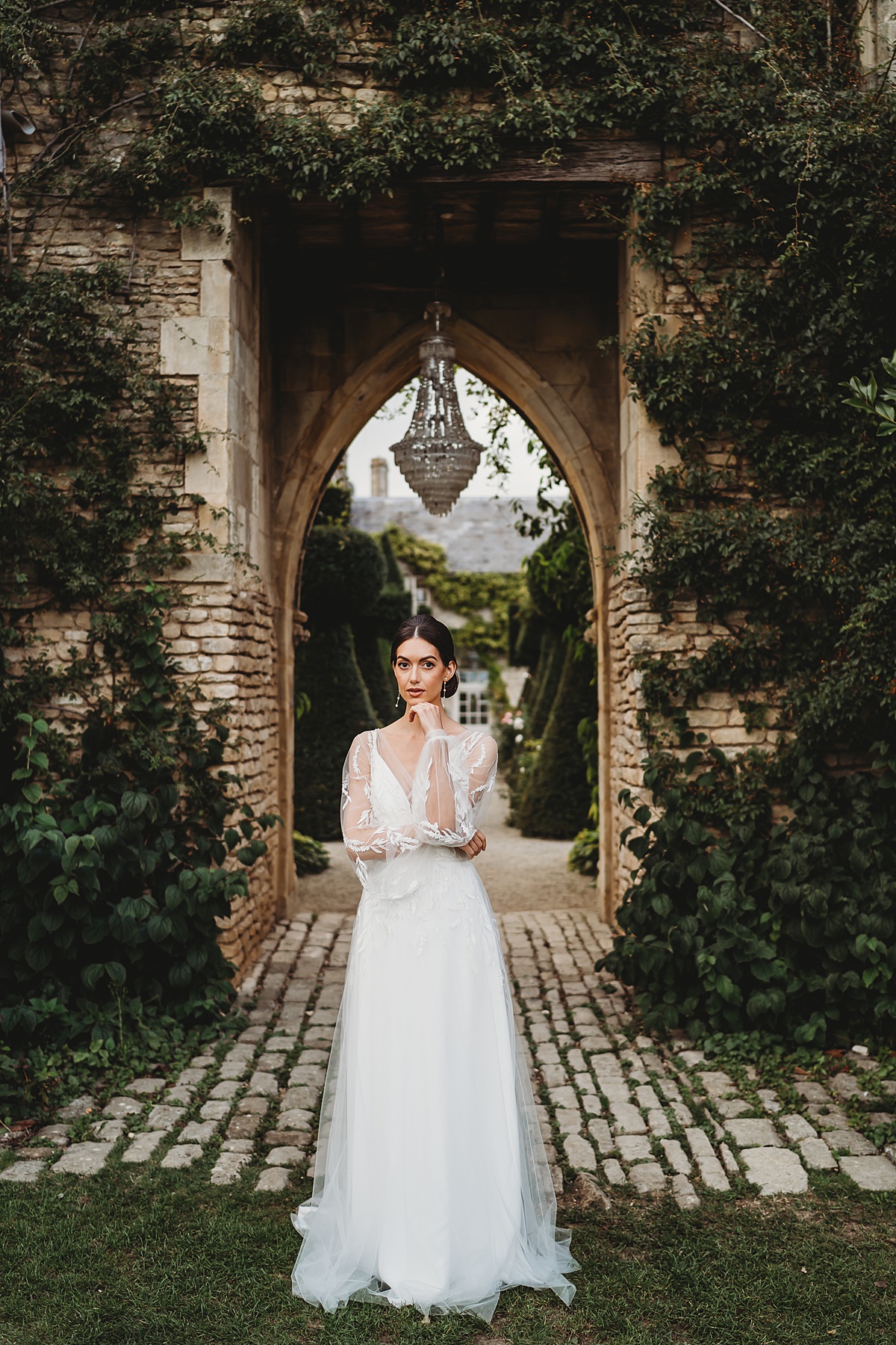 a bride resting her hand on her face as she poses for her bridal portraits at Euridge manor