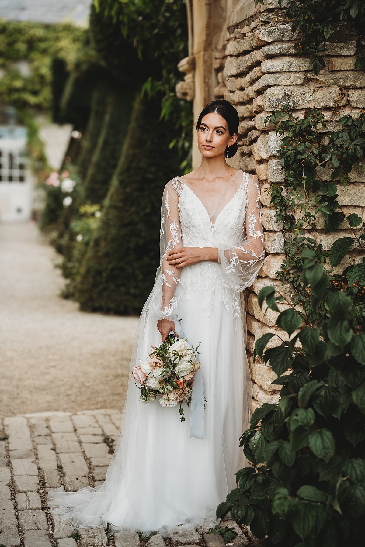 a bride leaning against a wall as she poses for her bridal portraits at Euridge manor