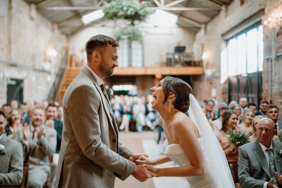 a bride laughs loudly after her and her husband have got married