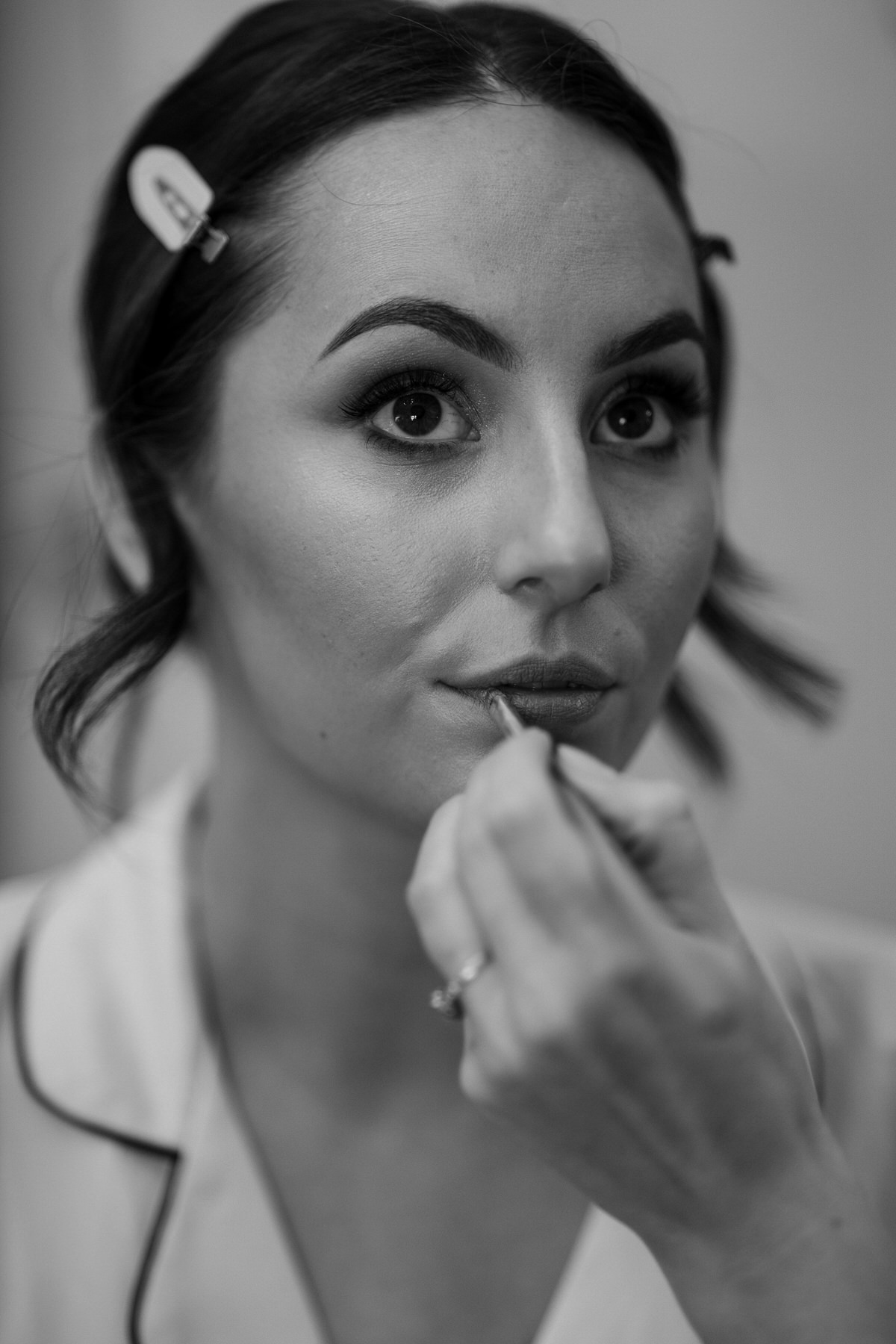 a bride having her lip stick applied during bridal prep taken by Botley Hill Barn Luxury Wedding Photographer