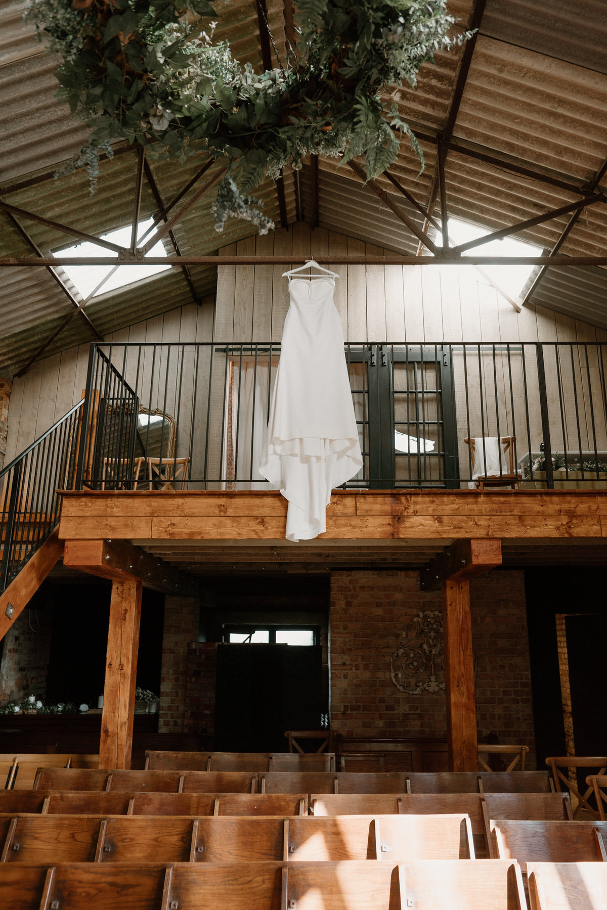 a wedding dress hanging up in a ceremony room at Botley Hill Barn