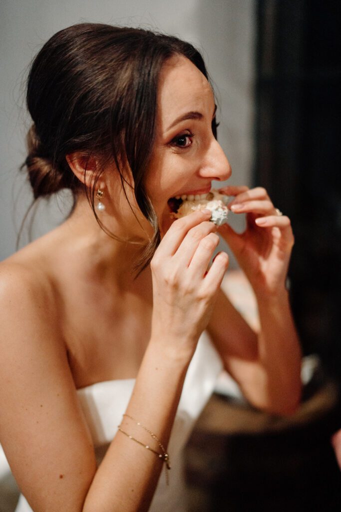 a bride eating a piece of her wedding cake from her wedding day for a Botley Hill Barn Luxury Wedding Photographer