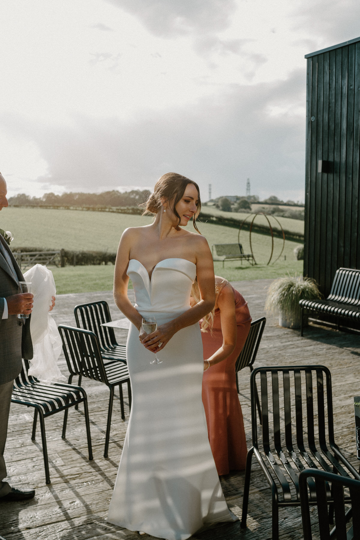 a bride having her dress tucked in before her wedding reception at Botley Hill Barn