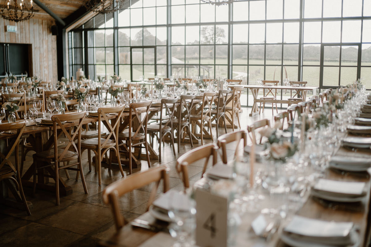 a cream themed table setting ready for a wedding breakfast at a surrey barn venue