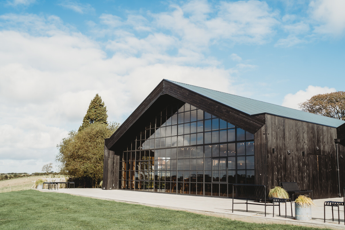 an outdoor image of botley hill barn wedding venue with blue dappled sky in the background