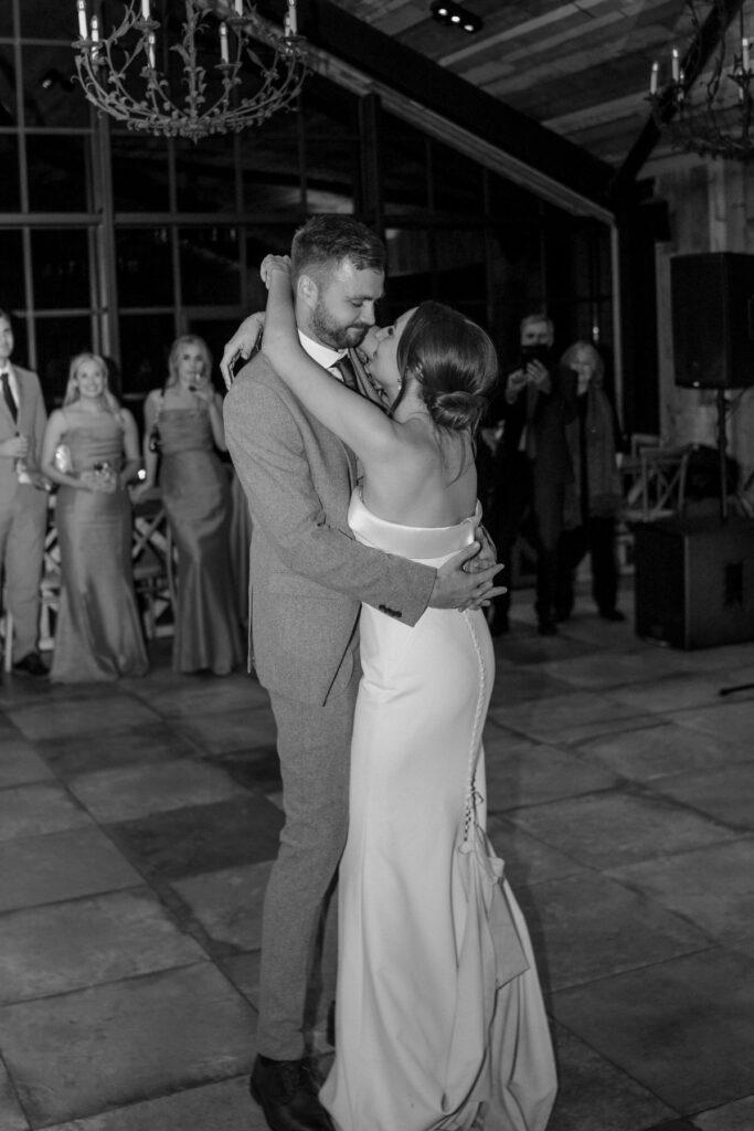 a bride and groom hugging as they have their first wedding dance