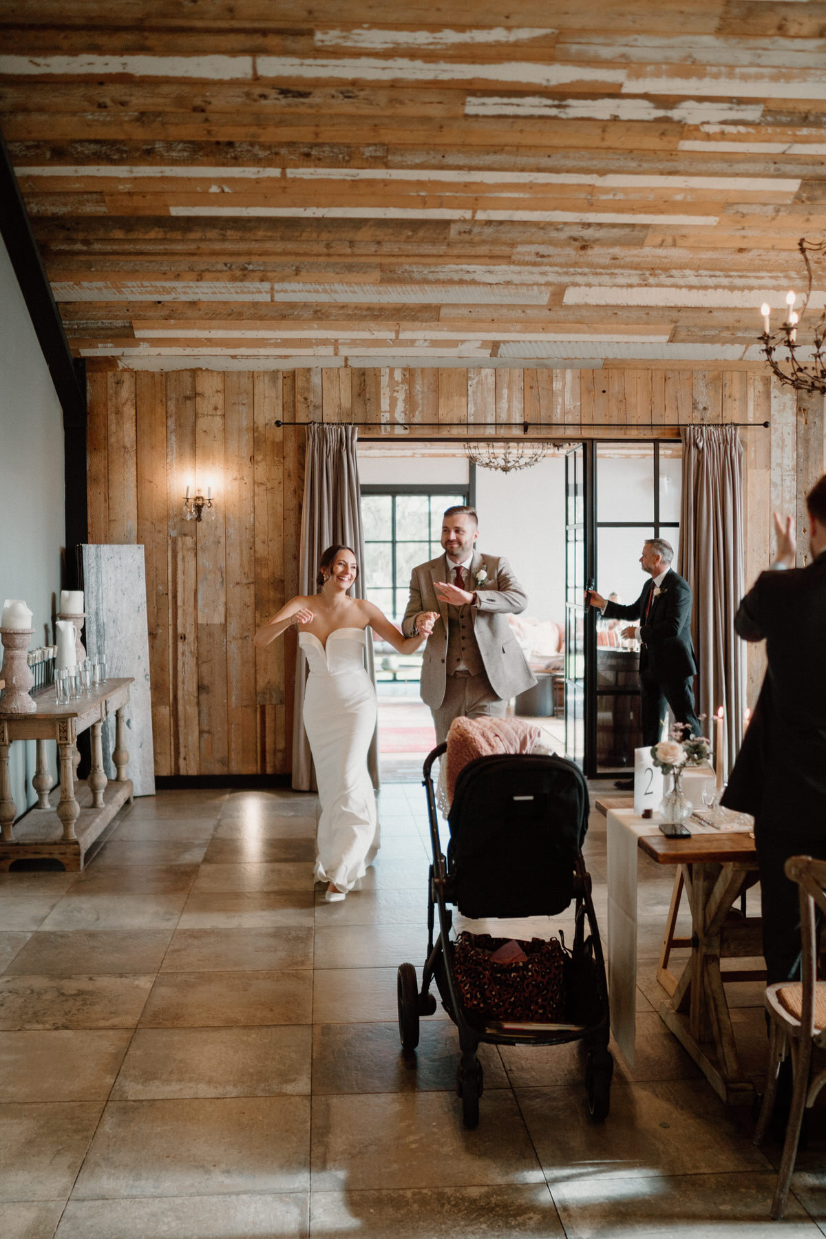 bride and groom enter their wedding breakfast dancing and singing at a surrey wedding venue